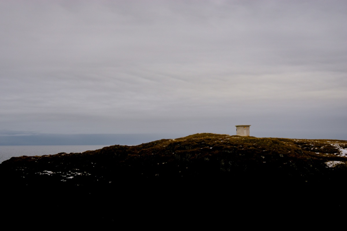 A small tower on top of a snow covered hill