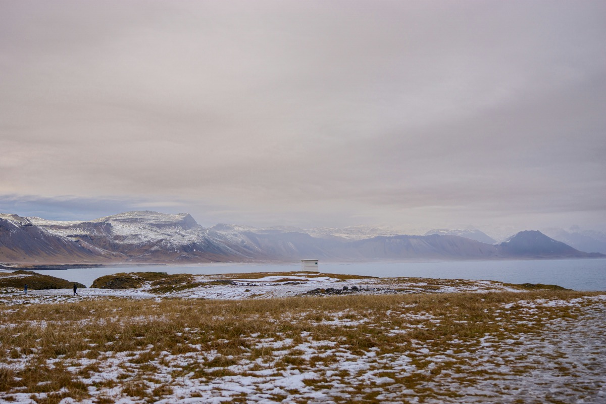 A snow covered field with mountains in the background
