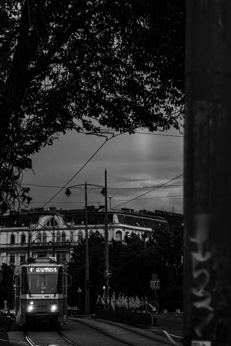 A black and white photo of a trolley on a street
