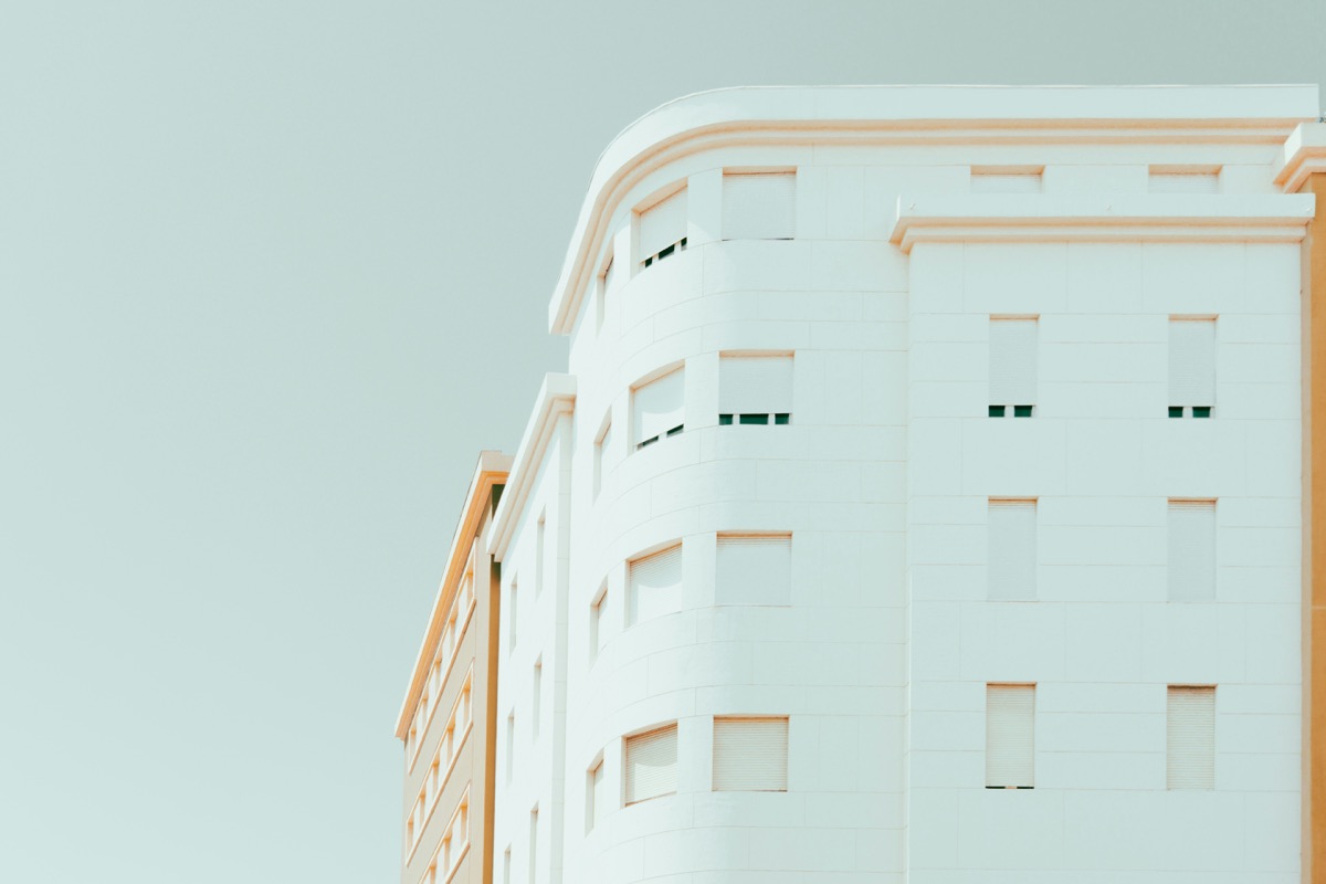 a tall white building with a clock on it's side