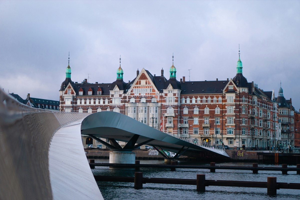 a bridge over a body of water with a building in the background