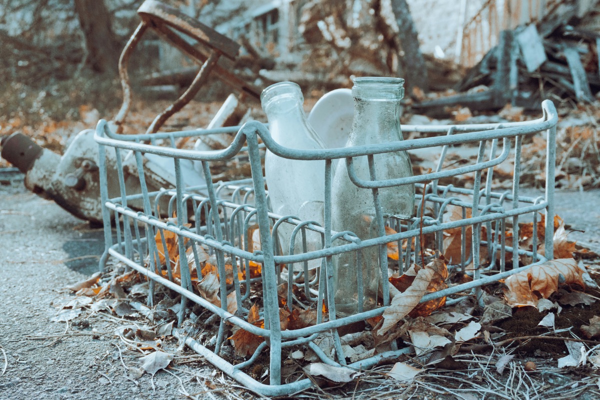 a broken dishwasher sitting on top of a pile of leaves
